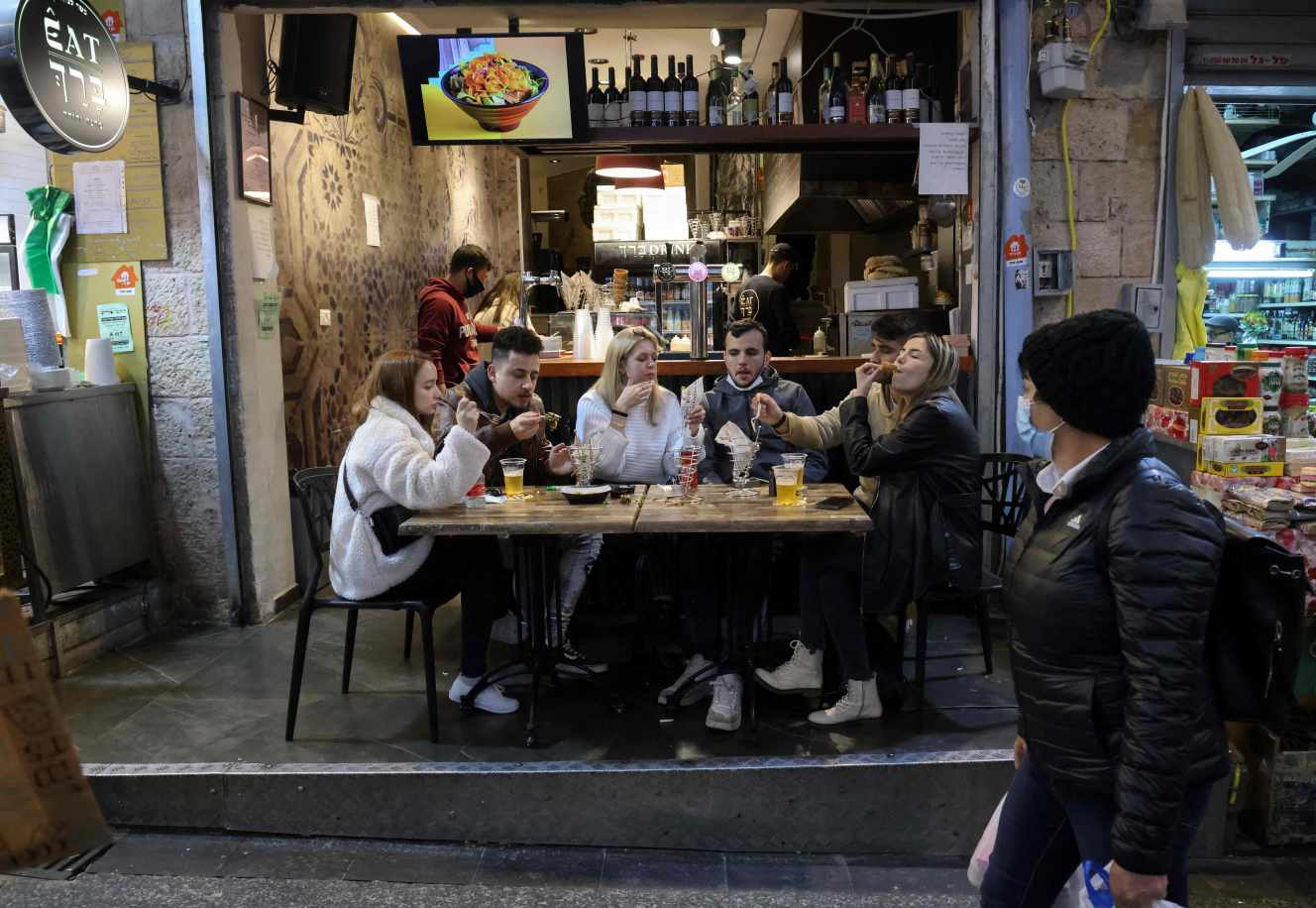 Des jeunes gens attablés dans un restaurant de Jérusalem, le 11 mars 2021. EMMANUEL DUNAND / AFP